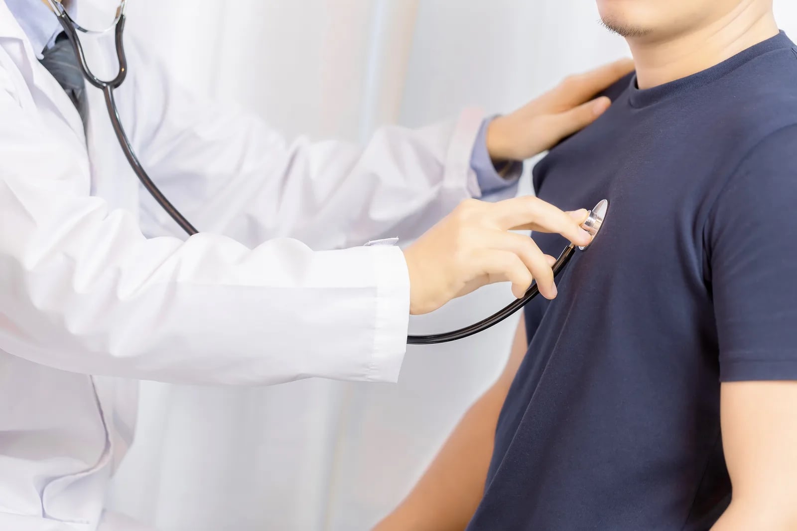 مختص يضع سماعة طبية على صدر رجل أثناء الفحص